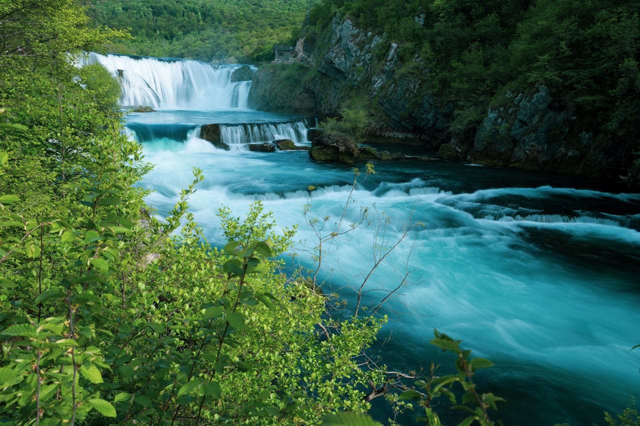 Majestic waterfall flowing through a lush green landscape, evoking serenity and natural beauty.