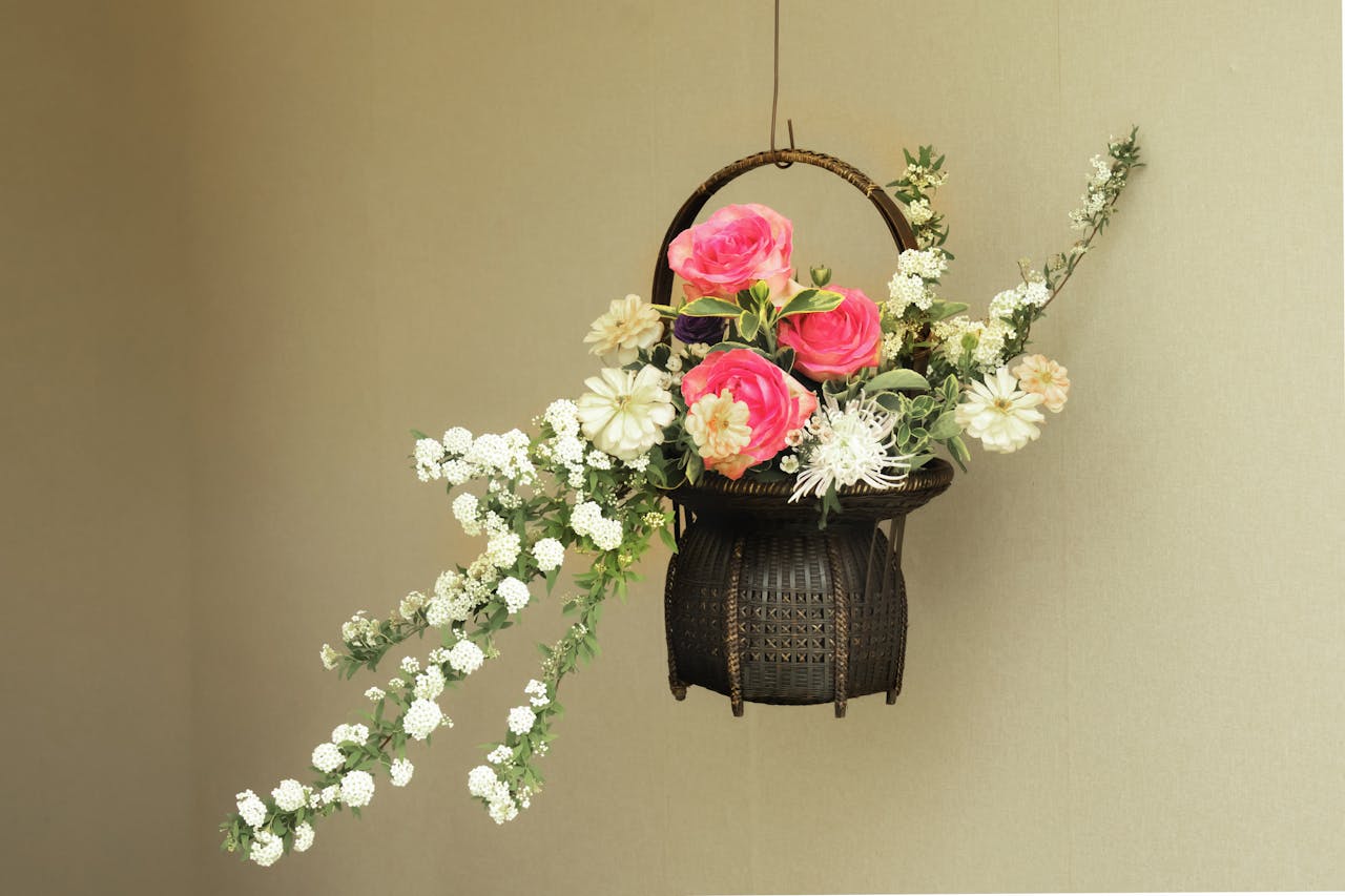 Beautiful floral arrangement featuring roses and white blooms in a traditional hanging basket.