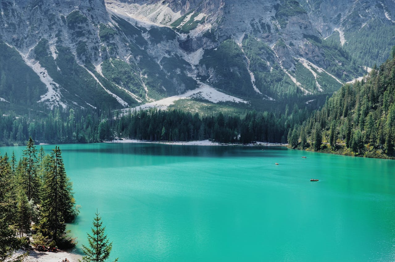 Explore this serene mountain lake with clear turquoise water and lush forests.
